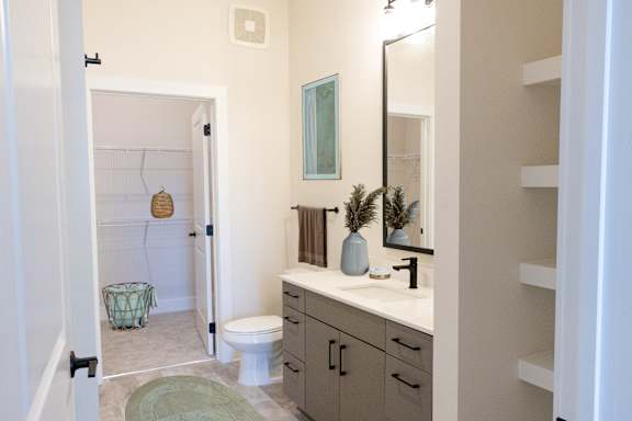 A bathroom with a toilet, sink, and mirror.at Riverside Apartments, Chattanooga, 37406