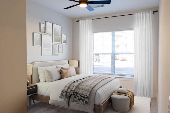A bedroom with a large bed and a window with white curtains.at Riverside Apartments, Chattanooga, Tennessee