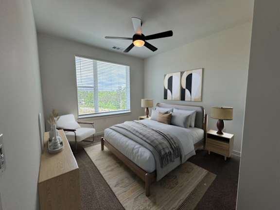 A bedroom with a bed, a chair, and a ceiling fan.