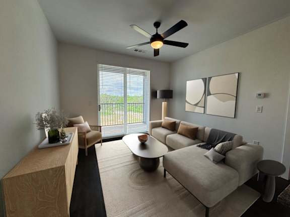 A living room with a sofa, a coffee table, and a ceiling fan.