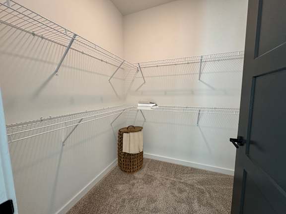 A walk-in closet with a basket on the floor.