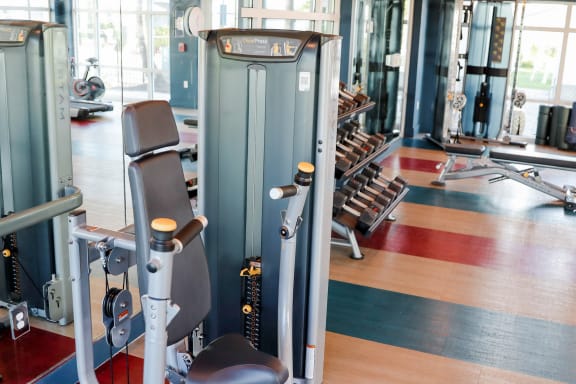 a gym with a variety of machines and weights at The Crest at Naples, Naples, FL