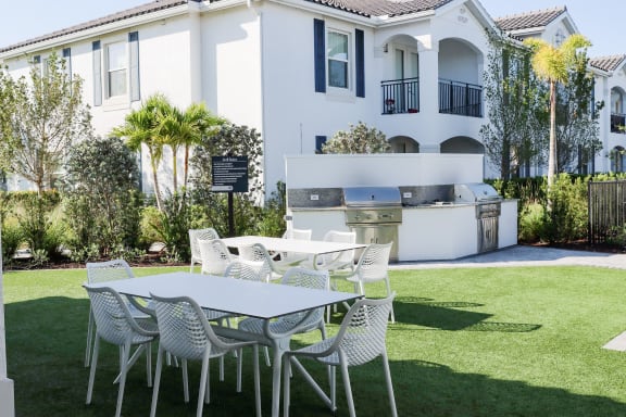 a table and chairs on a lawn in front of a house at The Crest at Naples, Naples, Florida