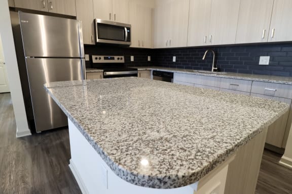 an island with granite countertop in a kitchen at The Crest at Acworth, Georgia, 30102