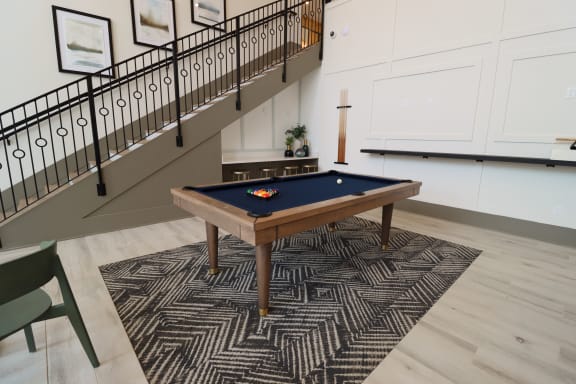 a pool table in a basement with a stairway in the background at The Crest at Acworth, Acworth, GA, 30102