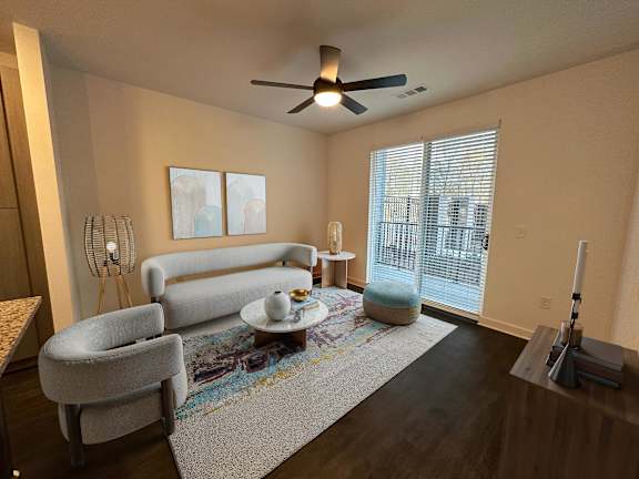 A living room with a grey sofa, a white table, and a rug.