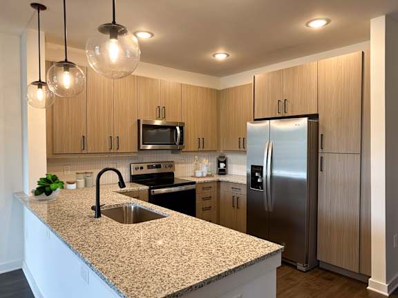 A kitchen with wooden cabinets and granite countertops.