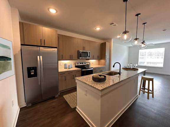 A modern kitchen with a granite countertop and stainless steel appliances.