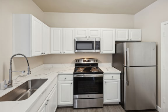 spacious kitchen with white cabinets and stainless steel appliances at Bridgeport Ranch apartments