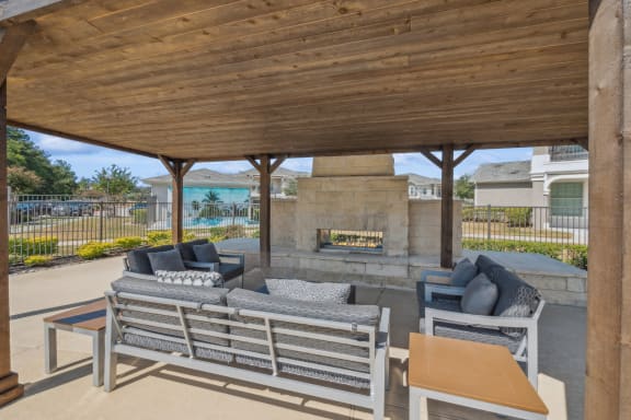 covered patio and fireside lounging area at Villages of Magnolia apartments