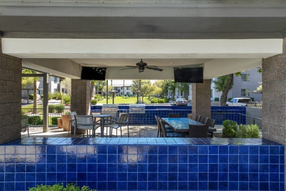 covered patio with grilling area and al fresco dining at Avora apartments