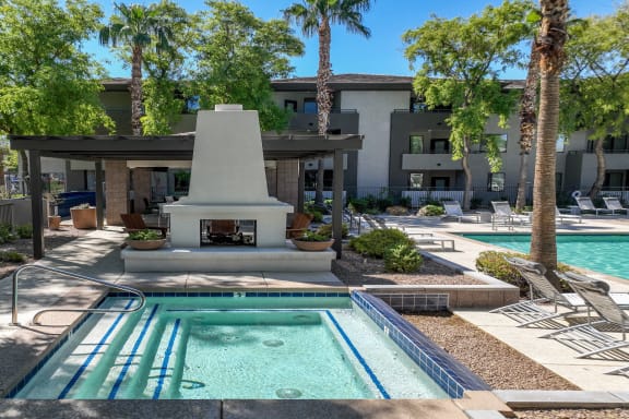 poolside covered lounging area with a fireplace at Avora apartments