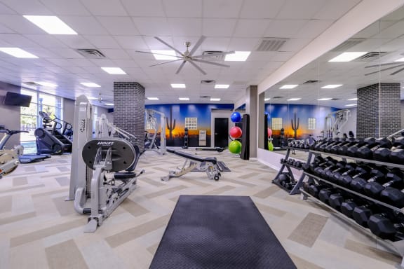 fitness center with weights and cardio machines at Roosevelt Square apartments