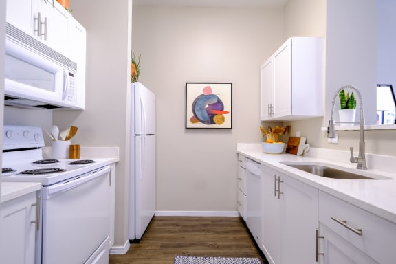 luxury kitchen with modern white cabinetry and gleaming countertops at Roosevelt Square apartments