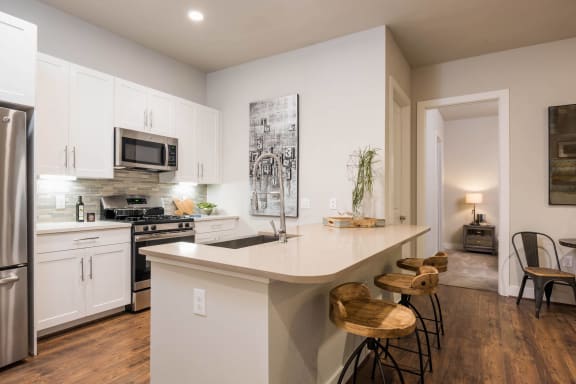 kitchen with modern white cabinetry and stainless appliances at Tinsley on the Park apartments