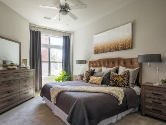 spacious bedroom with expansive windows and a ceiling fan at Tinsley on the Park apartments