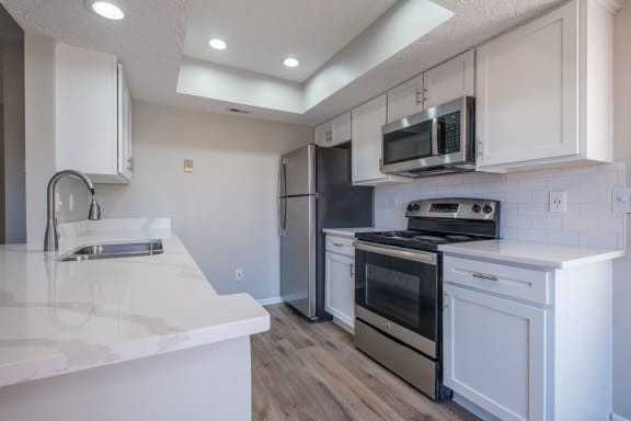 Perimeter Lakes apartments kitchen with white cabinets and stainless appliances