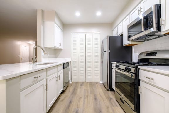 a kitchen with white cabinetry and a black stove top oven