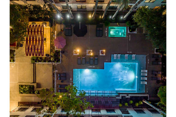 an aerial, night-time view of the pool at The Core apartments