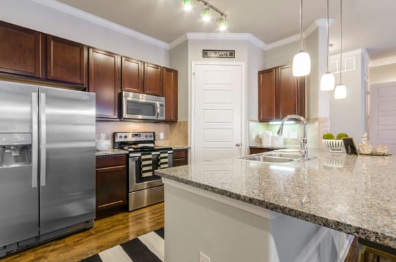 a kitchen with stainless steel appliances and granite counter tops at Park 3Eighty apartments