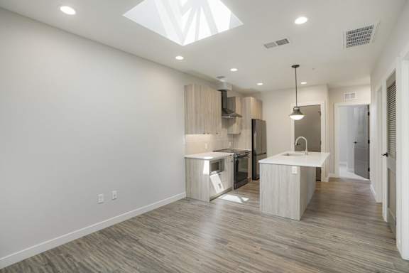 A modern kitchen with wooden floors and white walls at The Avenue Lofts Golden Apartments, Colorado, 80401