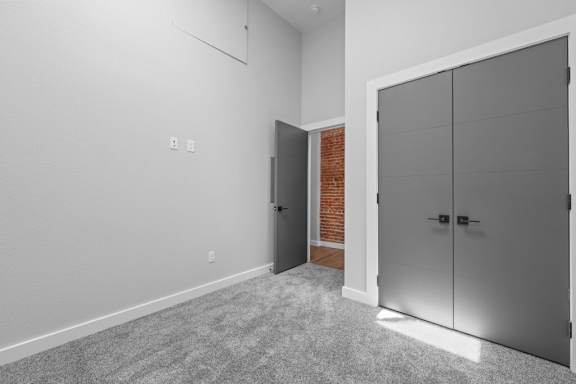 A room with a grey carpet and a grey wardrobe at The Avenue Lofts Golden Apartments, Colorado