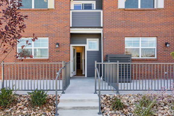 A red brick building with a grey door and windows.