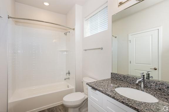 A white bathroom with a sink, toilet, and bathtub.