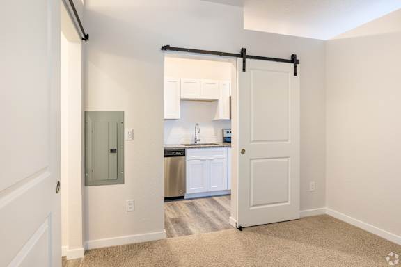 Bedroom with plush carpet and a white door at Brownstones at Palisade Park, CO, 80023.