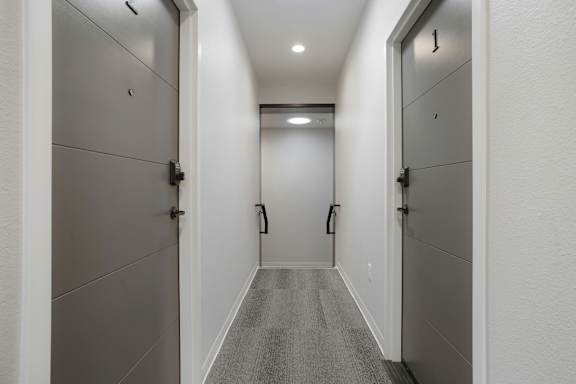 A long hallway with doors on both sides at The Avenue Lofts Golden Apartments, Golden