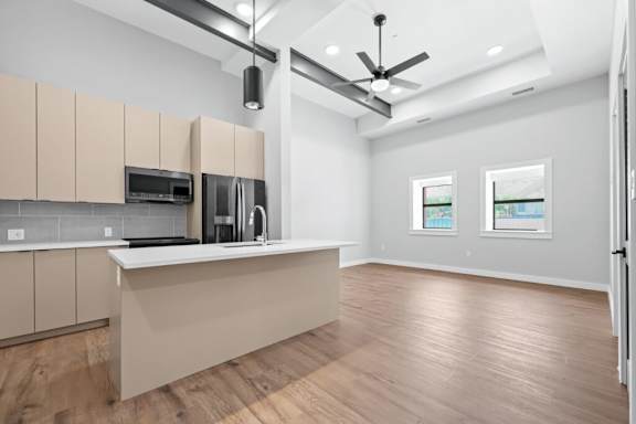 A kitchen with wooden floors and a countertop with a microwave and coffee maker at The Avenue Lofts Golden Apartments, Golden 80401