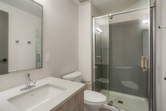 A modern bathroom with a sink, toilet, and shower at The Avenue Lofts Golden Apartments, Golden 80401
