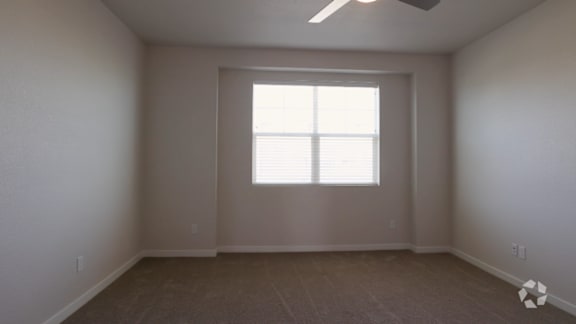 A room with a window and a ceiling fan.