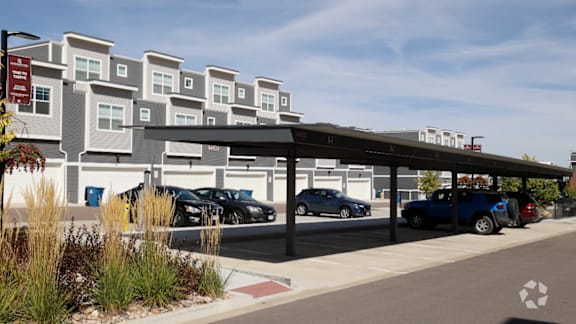 A parking lot with cars and a building in the background.