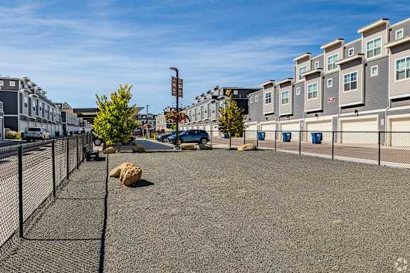 A parking lot with a fence and a building in the background.