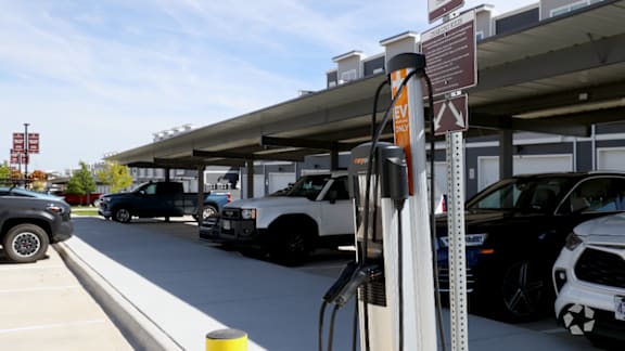 An electric vehicle charging station with a white truck parked at the pump.