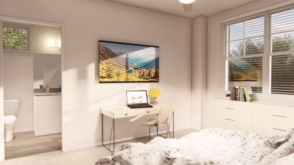a bedroom with a bed and a desk with a laptop at Brownstones at Palisade Park Townhomes, Colorado