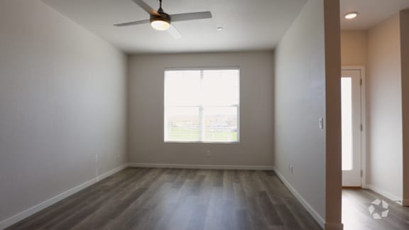 A room with a ceiling fan and a window.