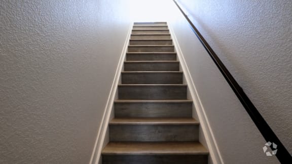 A staircase with a metal railing on the right side.