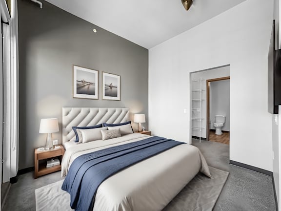 a bedroom with a large bed and a bathroom with a toilet