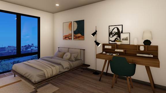 A bedroom with a bed, desk, and chair.