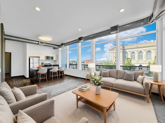 a living room with couches and a coffee table and a view of a building