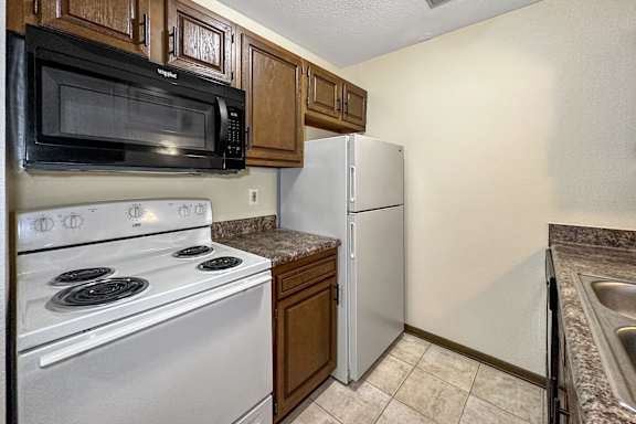 A kitchen with a white stove and a white refrigerator.