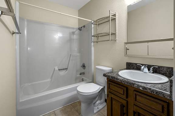 A white toilet sits next to a sink in a bathroom.