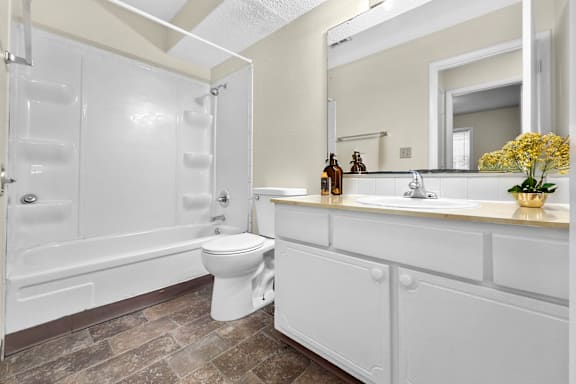 A white bathroom with a toilet, sink, and tub.