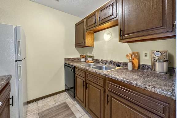 A kitchen with brown cabinets and a granite countertop.