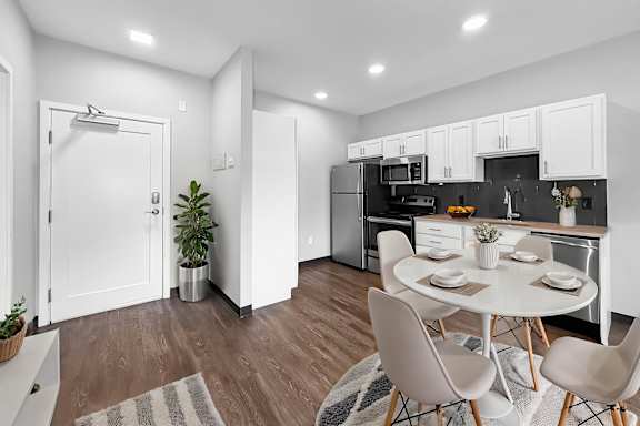 A modern kitchen with a dining table set for two.