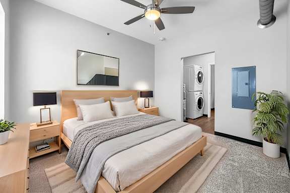 A bedroom with a bed, nightstand, and a ceiling fan.