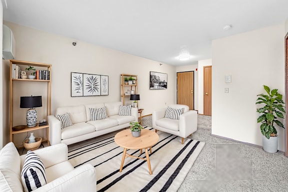 A living room with a white couch and a wooden coffee table.