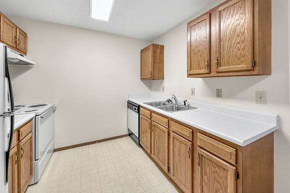 A kitchen with wooden cabinets and a white countertop.